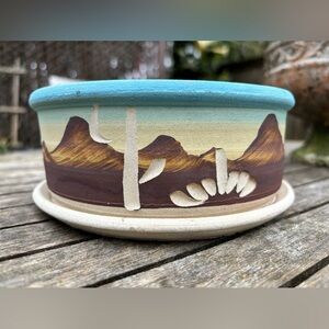 Southwestern style planter with a desert scene having cacti and mountains.